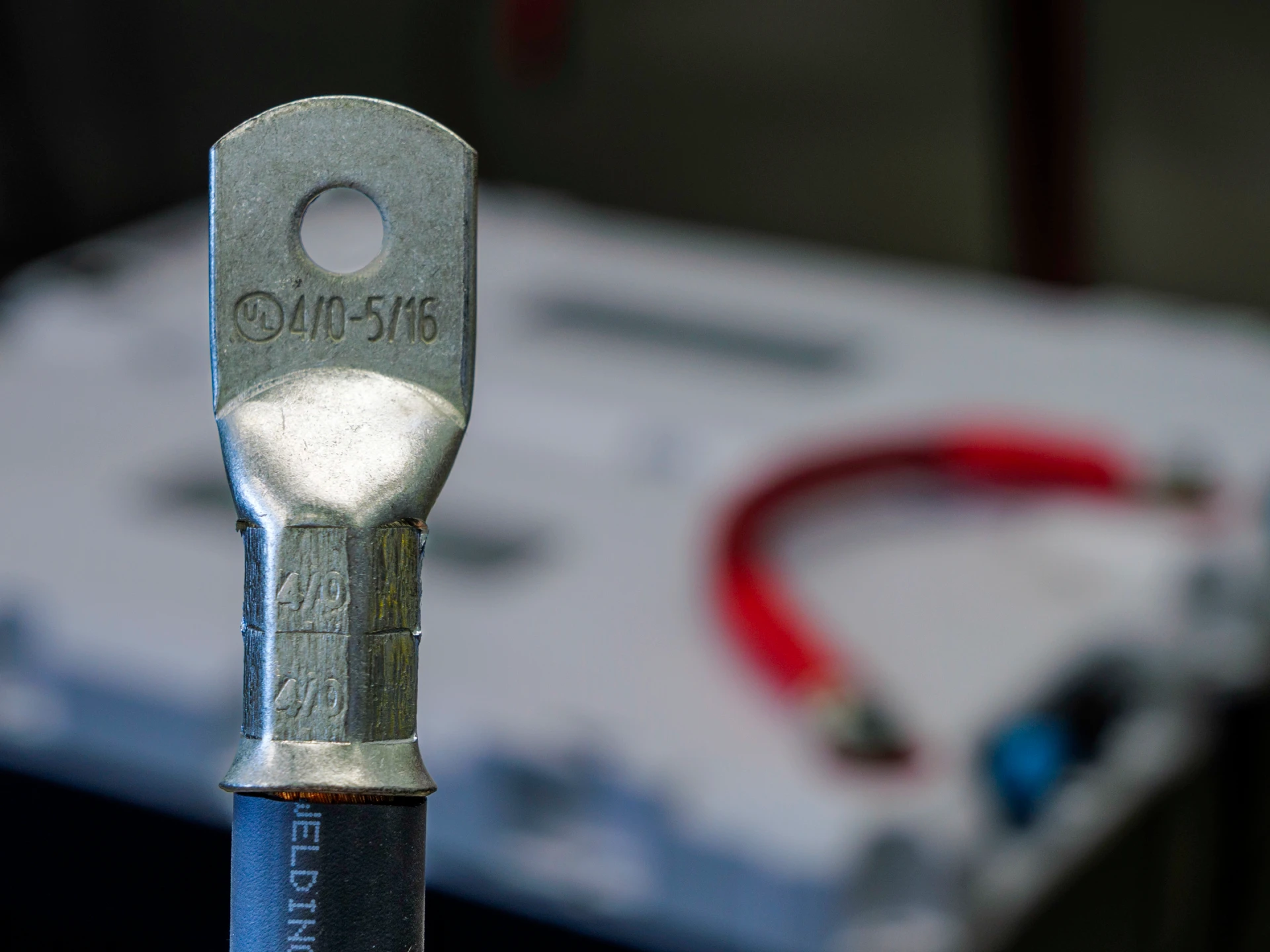 Close up photo of 4/0 lug in front of LFP batteries